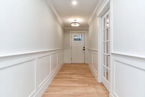 a view of a hallway with wooden floor and entryway