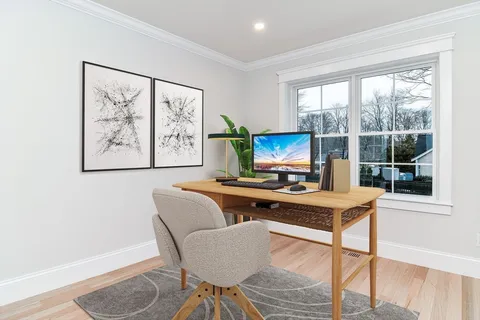 a view of a workspace with furniture and a window
