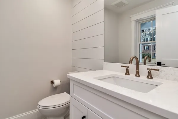 a bathroom with a sink a toilet and mirror