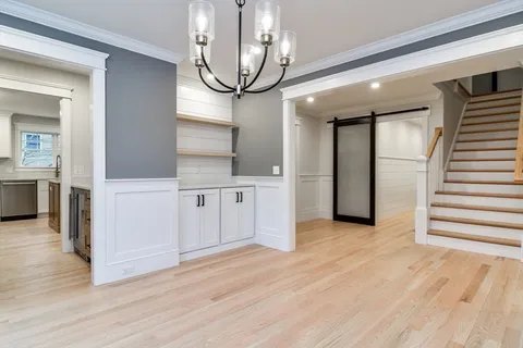 a view of a hallway with wooden floor and staircase