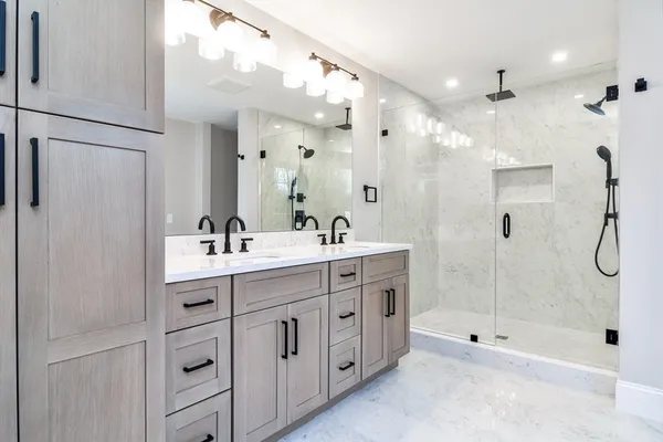 a bathroom with a double vanity sink mirror and shower