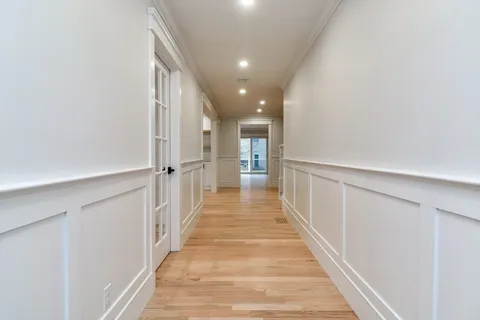 a view of a hallway with wooden floor and staircase