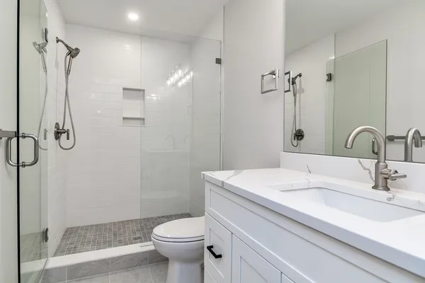 a bathroom with a sink a toilet and shower
