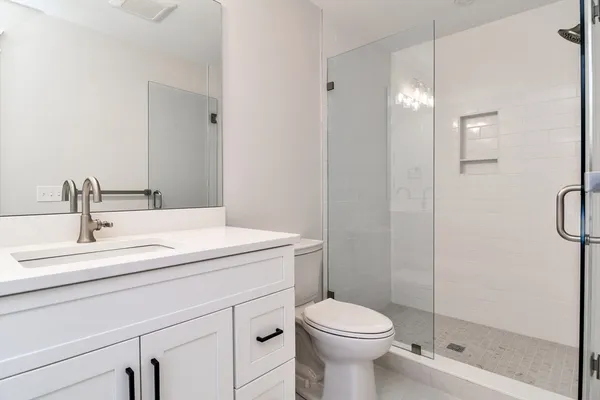 a bathroom with a sink a toilet and shower