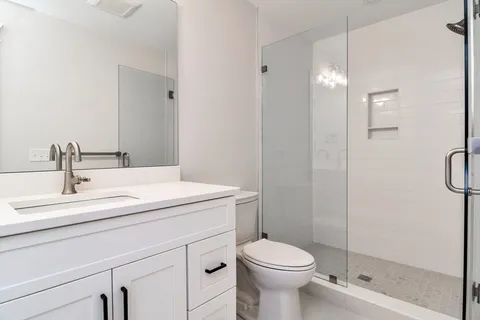 a bathroom with a sink a toilet and shower