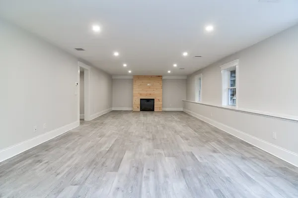 an empty room with wooden floor and a window