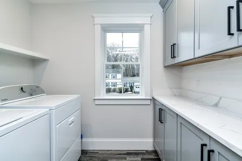 a utility room with cabinets washer and dryer