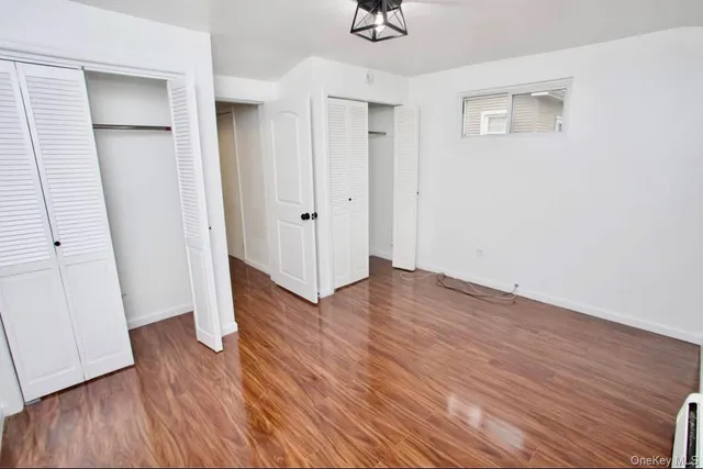 a view of a hallway with wooden floor and entryway
