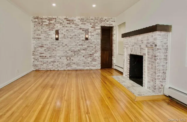 a view of empty room with wooden floor and fireplace