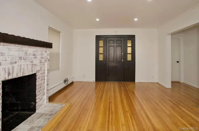 a view of empty room with wooden floor and fireplace