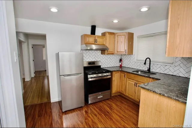 a kitchen with granite countertop a sink and a refrigerator