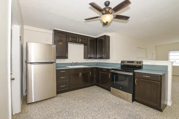a kitchen with stainless steel appliances granite countertop a refrigerator a stove a sink and a refrigerator