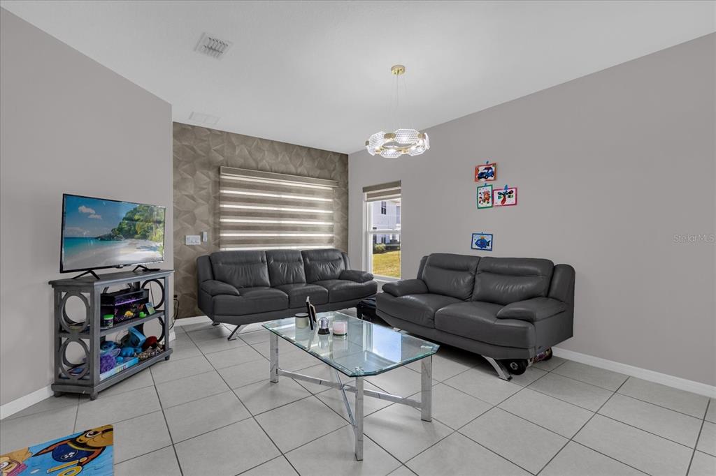 3470 Beau Road Kissimmee, FL 34746 - Photo 9 of 40 a living room with furniture and a flat screen tv