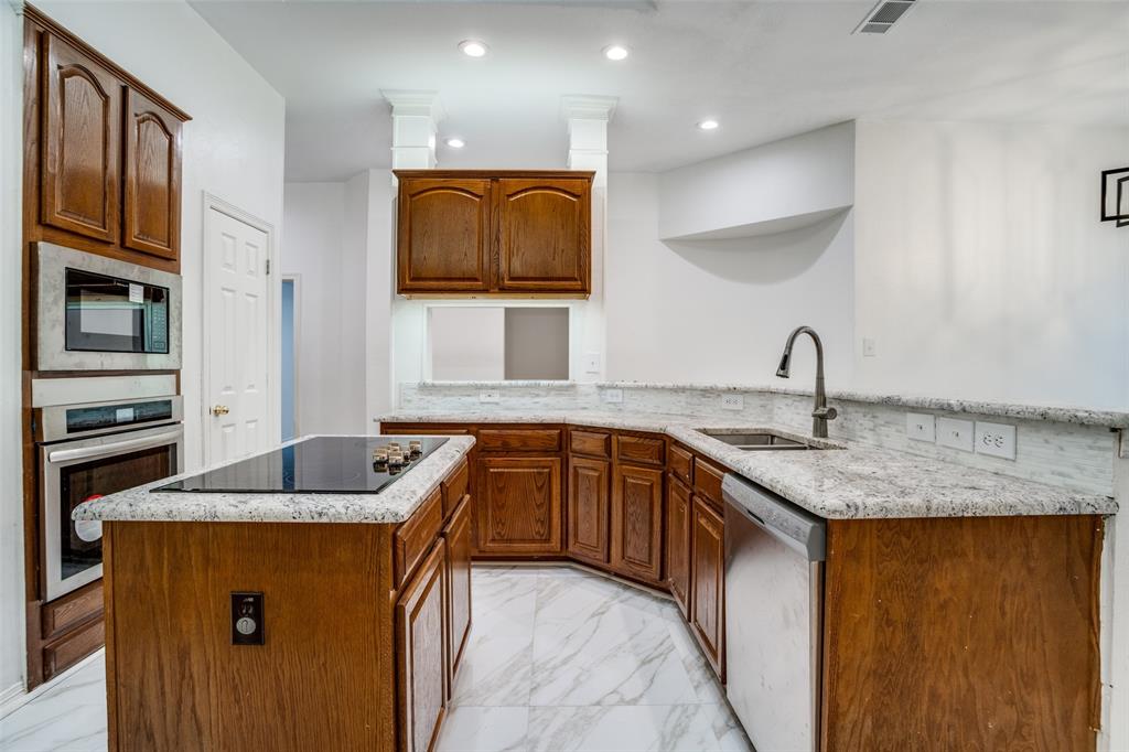 901 Autumn Ridge Drive McKinney, TX 75072 - Photo 11 of 24 a kitchen with granite countertop a sink and cabinets