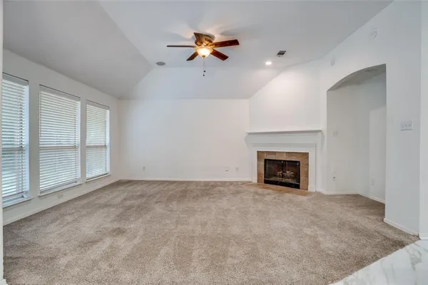 an empty room with fan and windows