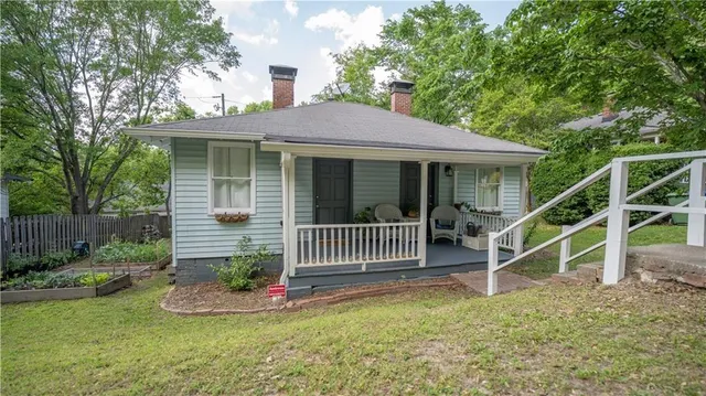 a view of house with a yard and a garden