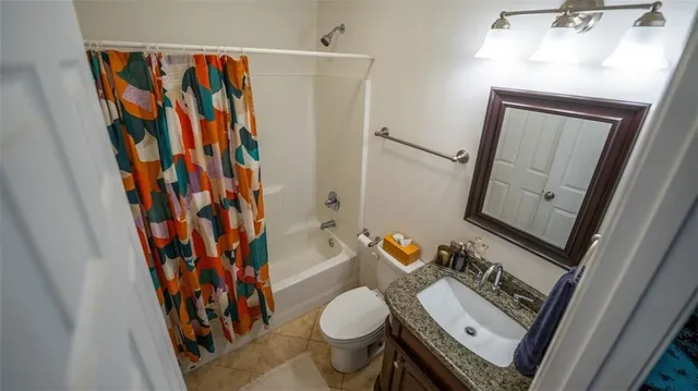 a bathroom with a toilet and a shower curtain