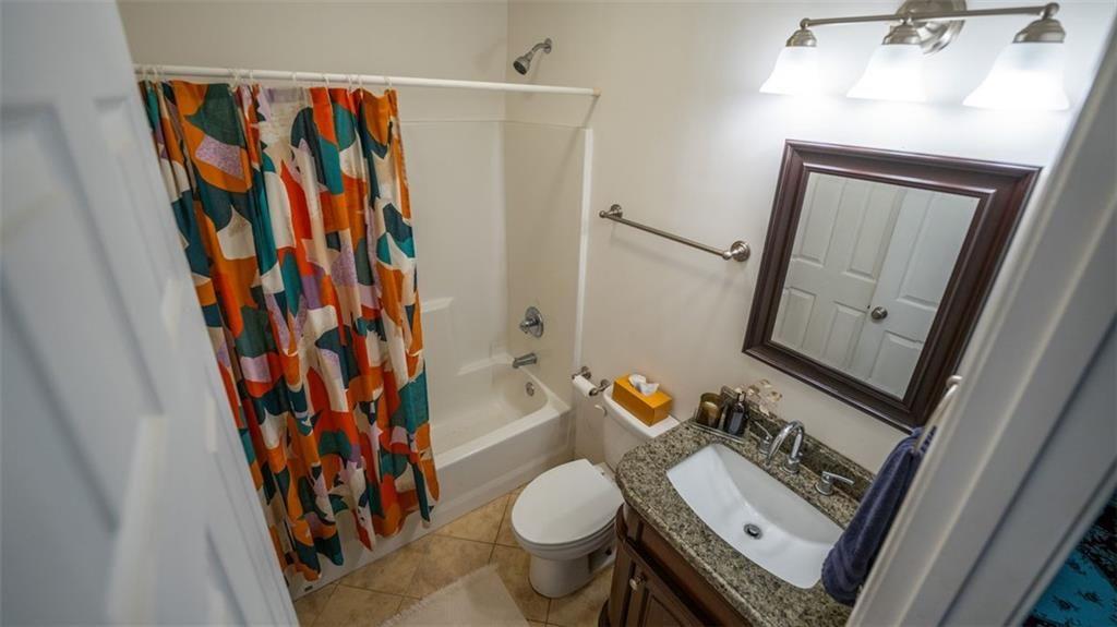2881 Parrott Avenue Northwest Atlanta, GA 30318 - Photo 26 of 32 a bathroom with a toilet and a shower curtain