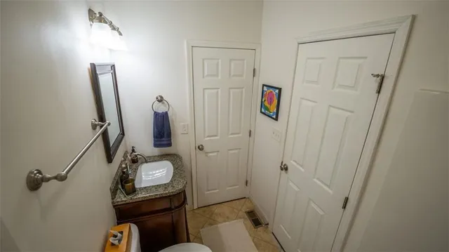 a bathroom with a sink and mirror with toilet