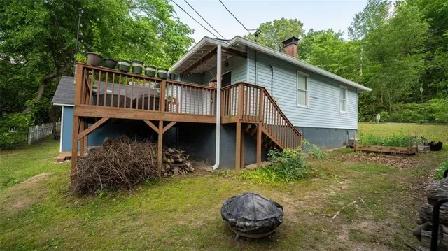a view of a small house with roof deck and backyard