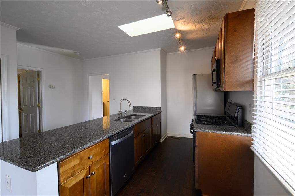 2881 Parrott Avenue Northwest Atlanta, GA 30318 - Photo 9 of 32 a kitchen with stainless steel appliances granite countertop a sink a stove and a refrigerator