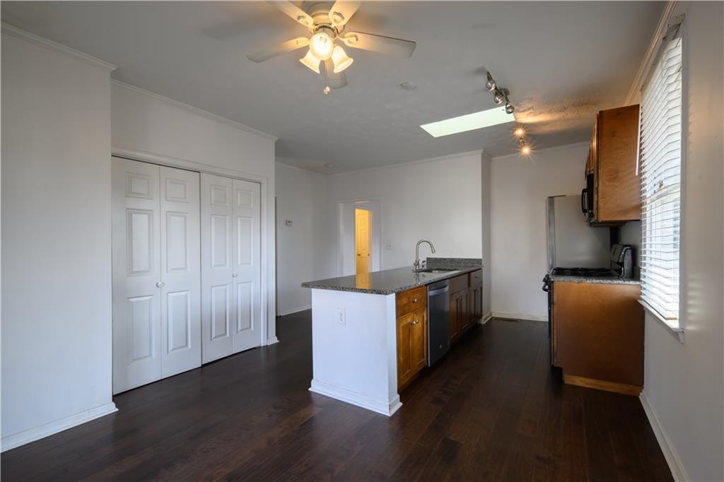 2881 Parrott Avenue Northwest Atlanta, GA 30318 - Photo 10 of 32 a kitchen with stainless steel appliances granite countertop a refrigerator a sink dishwasher a stove and a dining table with wooden floor