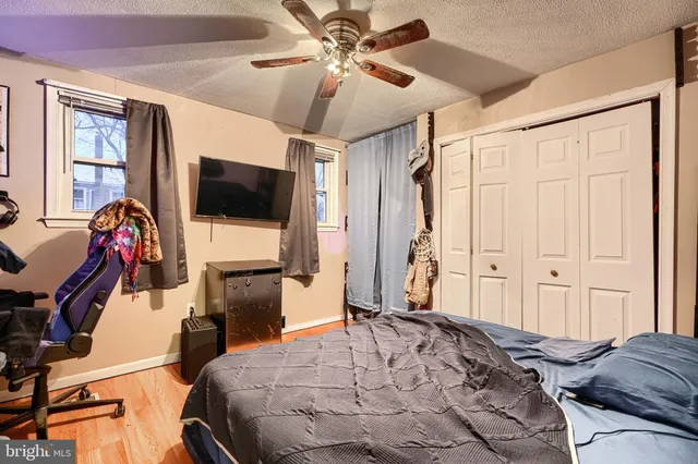 a bedroom with a bed and a flat tv screen on dresser