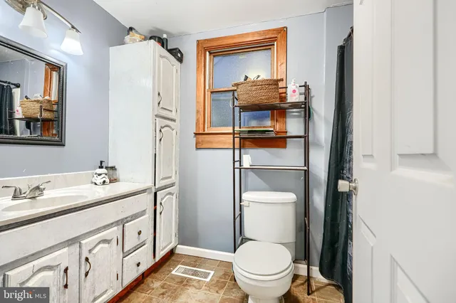 a bathroom with a toilet sink and mirror