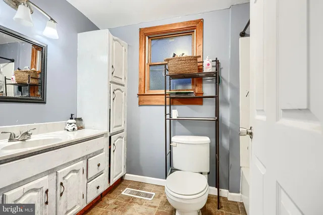 a bathroom with a toilet sink and mirror