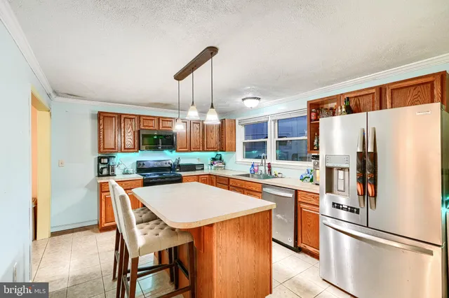 a kitchen with stainless steel appliances a refrigerator a stove a sink and a refrigerator