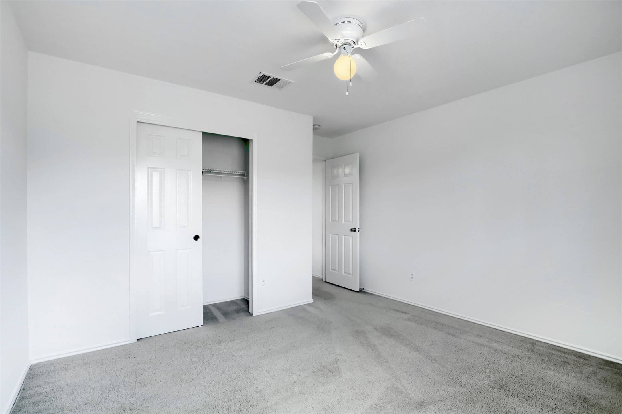 4125 Pebble Ridge Cove Round Rock, TX 78681 - Photo 26 of 30 A well-lit bedroom with soft carpet, an open closet, and a ceiling fan for comfort.