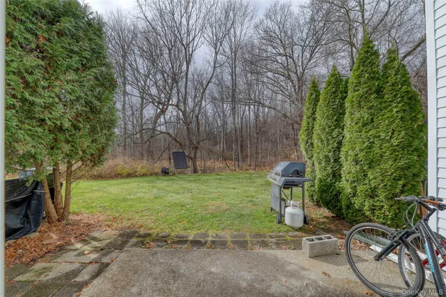 a backyard of a house with trees and outdoor seating