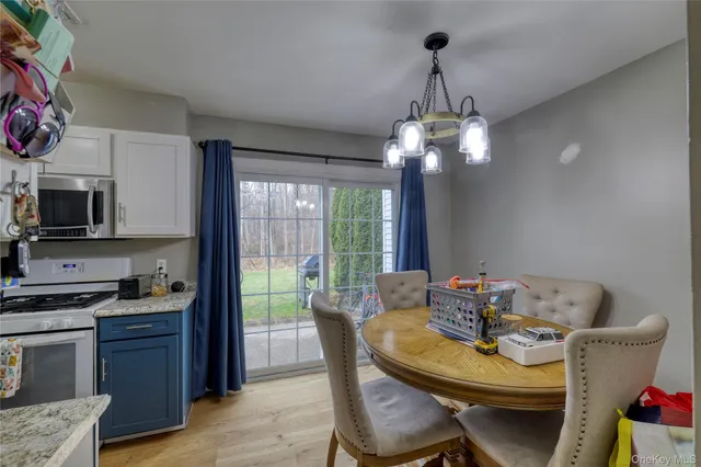 a dining room with furniture a chandelier and wooden floor