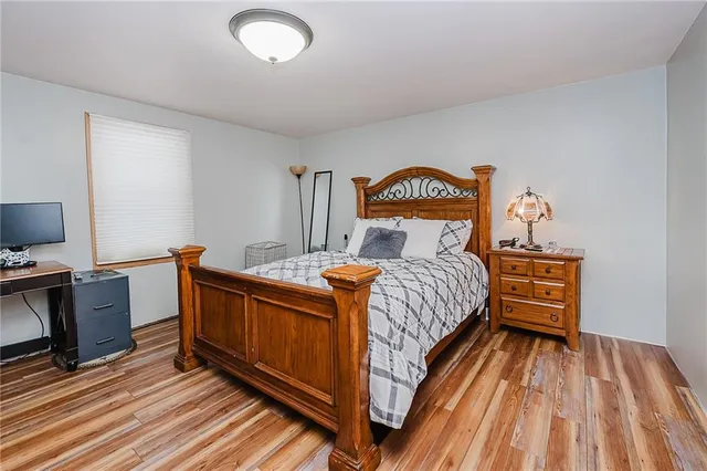 a bed sitting in a bedroom next to a window with pc on the wall