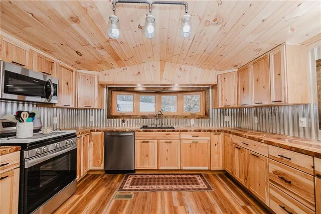 a kitchen with stainless steel appliances a stove sink and cabinets