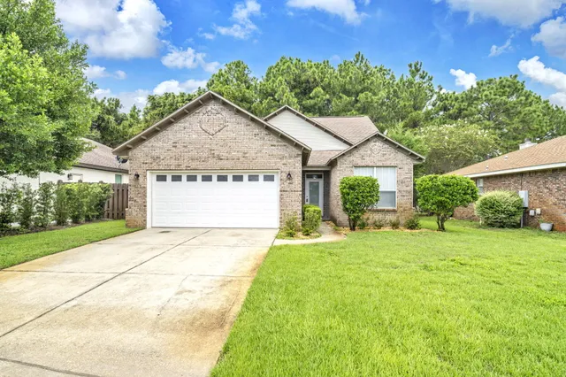 a front view of a house with yard and green space