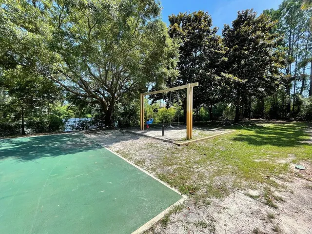 an aerial view of residential houses with outdoor space and trees