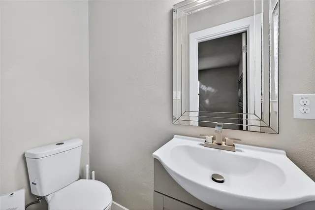 a bathroom with a toilet sink and mirror