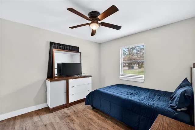 a living room with a bed furniture and a flat screen tv
