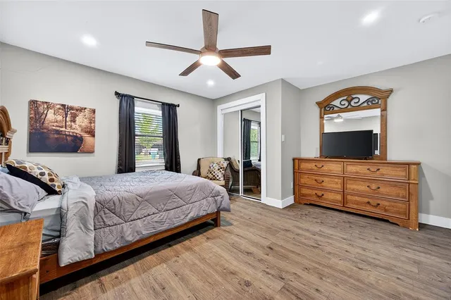 a bedroom with a bed and a flat tv screen on dresser