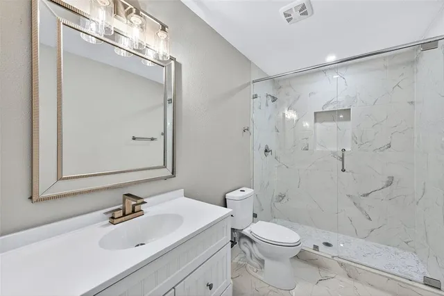 a bathroom with a sink toilet and shower