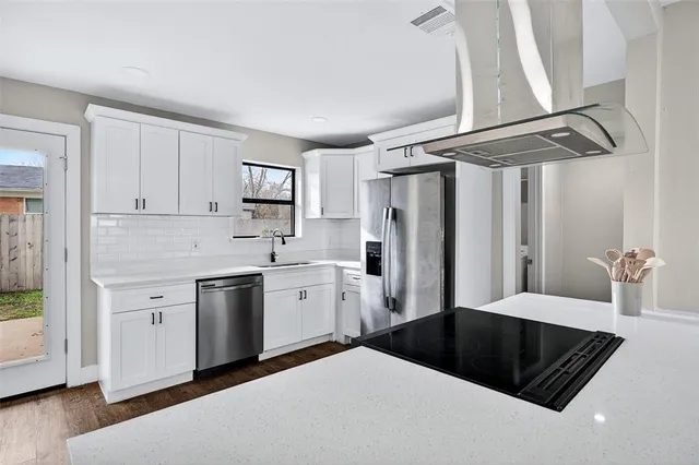 a kitchen with stainless steel appliances a refrigerator sink and cabinets
