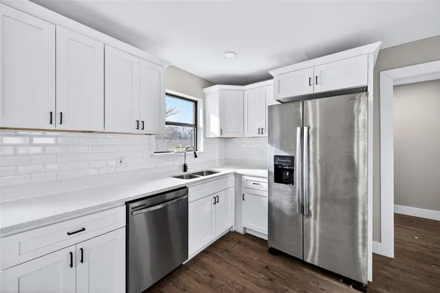 a kitchen with stainless steel appliances a refrigerator sink and cabinets