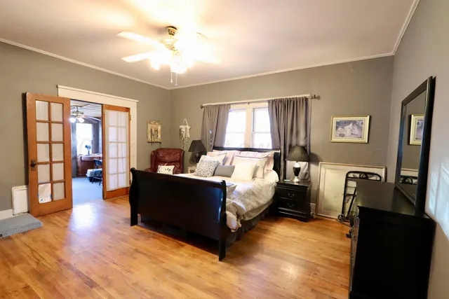 a room with chandelier fan and windows