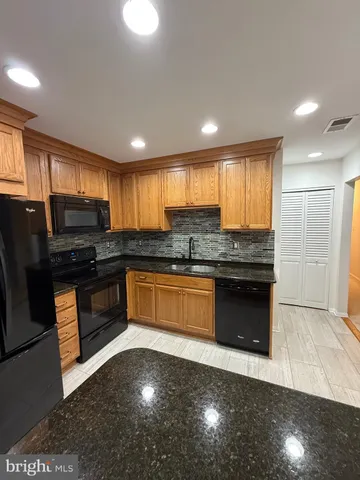 a kitchen with granite countertop stainless steel appliances and cabinets
