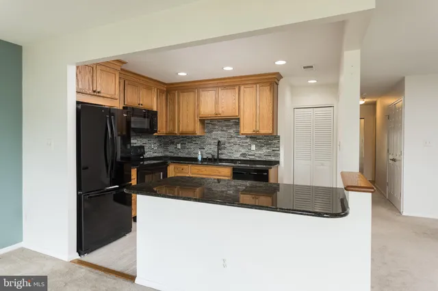 a kitchen with granite countertop a refrigerator and a sink