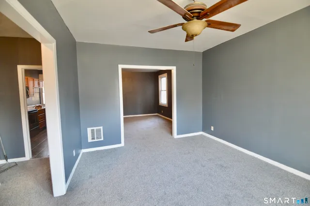 a view of an empty room with a ceiling fan