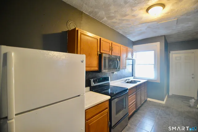 a kitchen with stainless steel appliances a refrigerator sink and stove