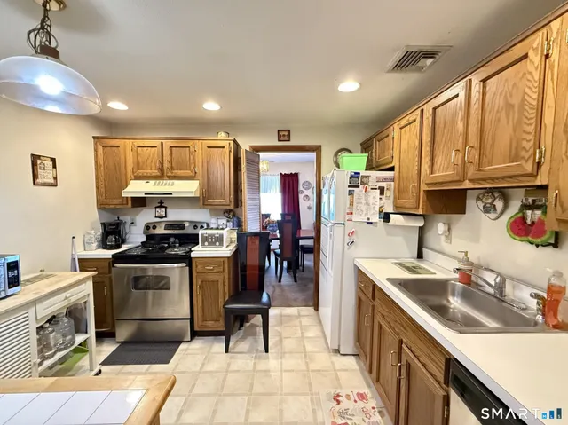 a kitchen with stainless steel appliances granite countertop a sink stove and refrigerator