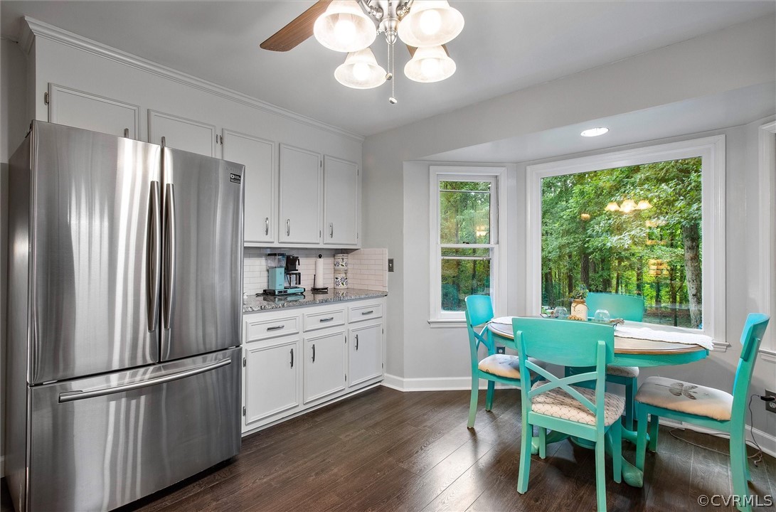 12808 Middlebrook Road Chester, VA 23831 - Photo 11 of 35 a kitchen with stainless steel appliances granite countertop a refrigerator a sink dishwasher a dining table and chairs with wooden floor